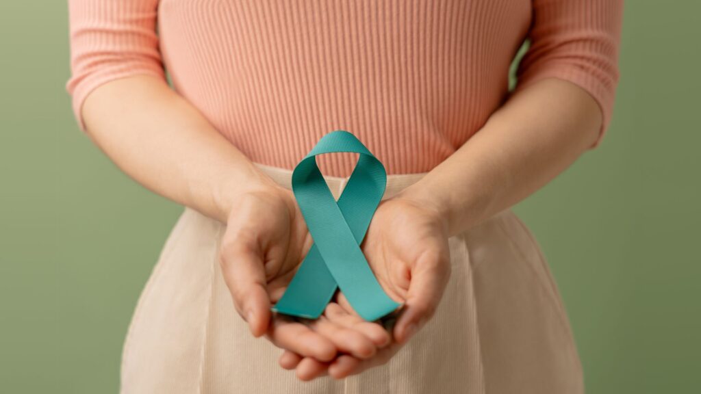 Person holding a teal ribbon to represent cervical cancer awareness