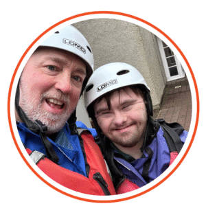 Dan smiling with a volunteer at Water Park, both wearing helmets and safety gear.