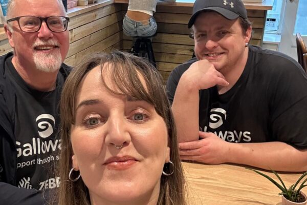 2 volunteers and a staff member in a cafe.